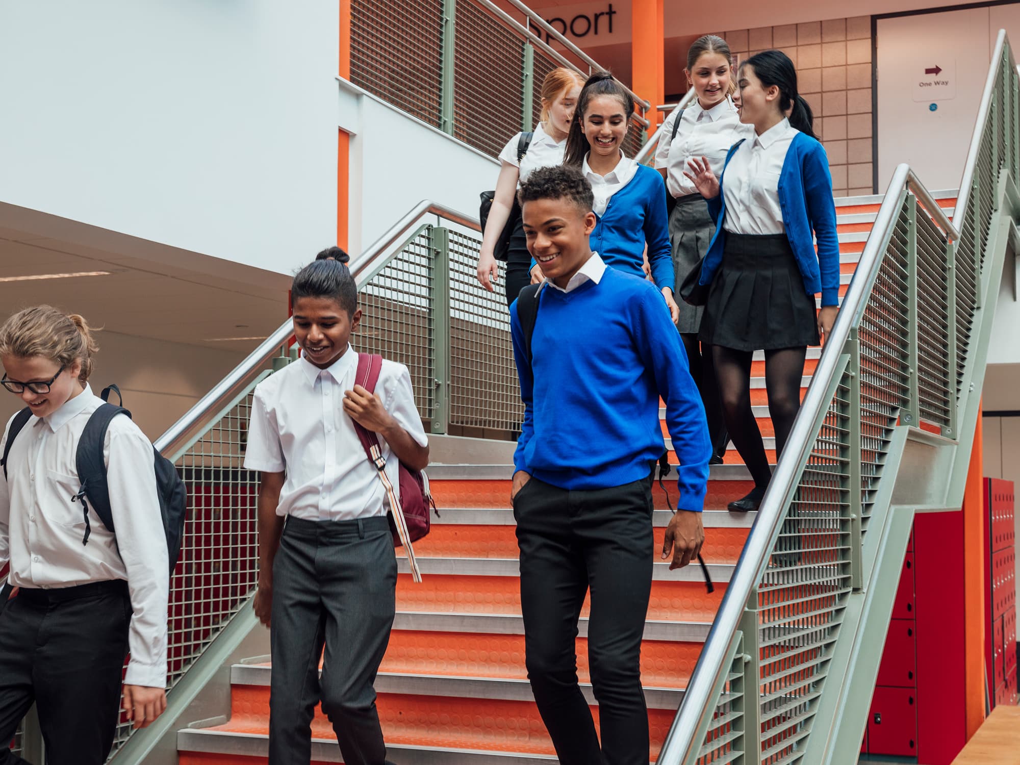 Diverse group of middle school kids walking down the stairs