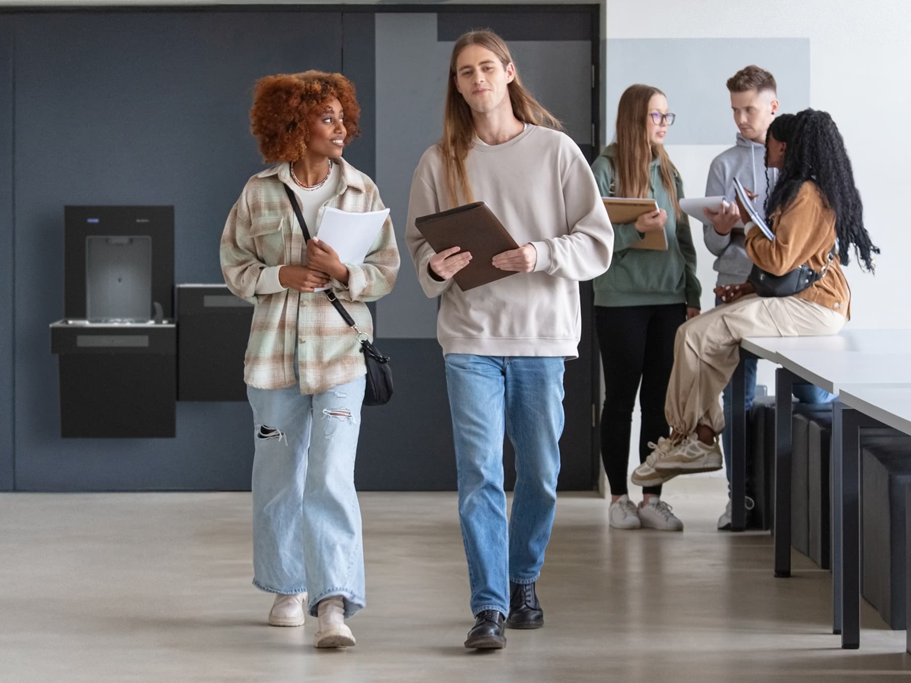 Students walking in school near water cooler