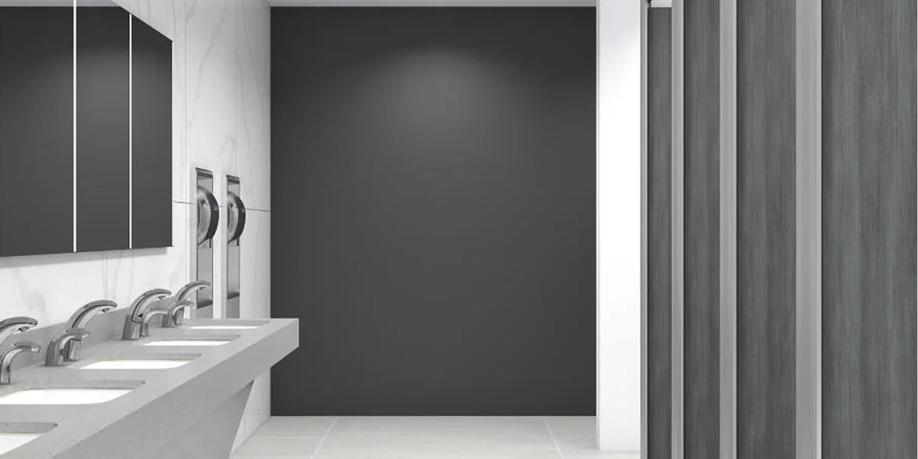 Coworking space restroom with white sinks, mirrors, and dark accent wall.