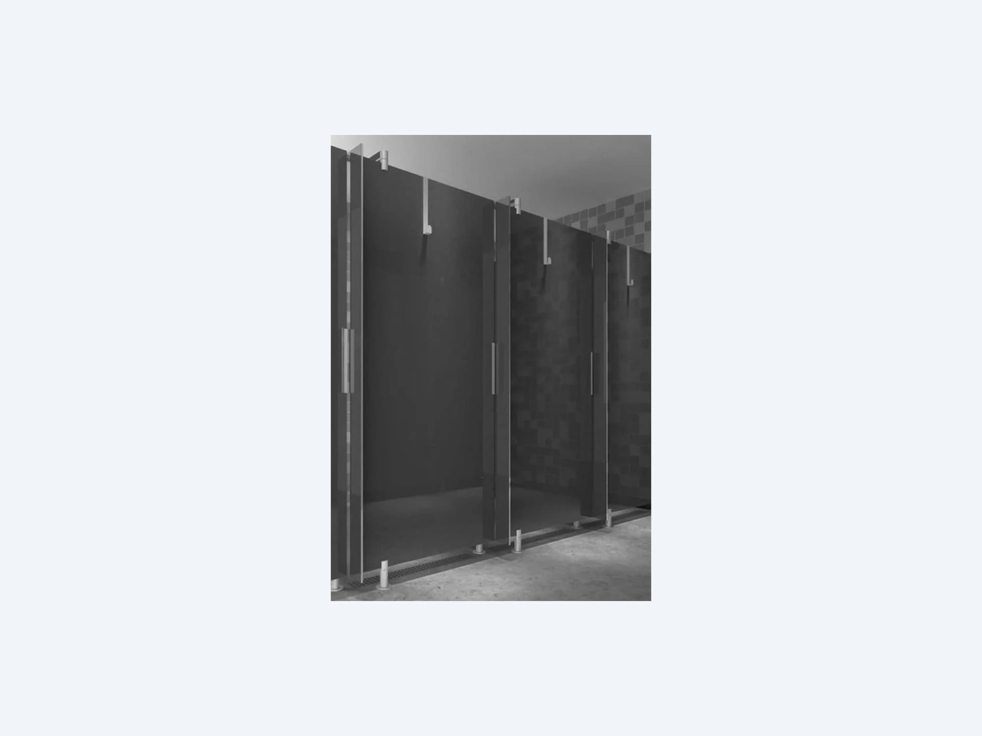 Series of dark restroom stalls with solid partitions