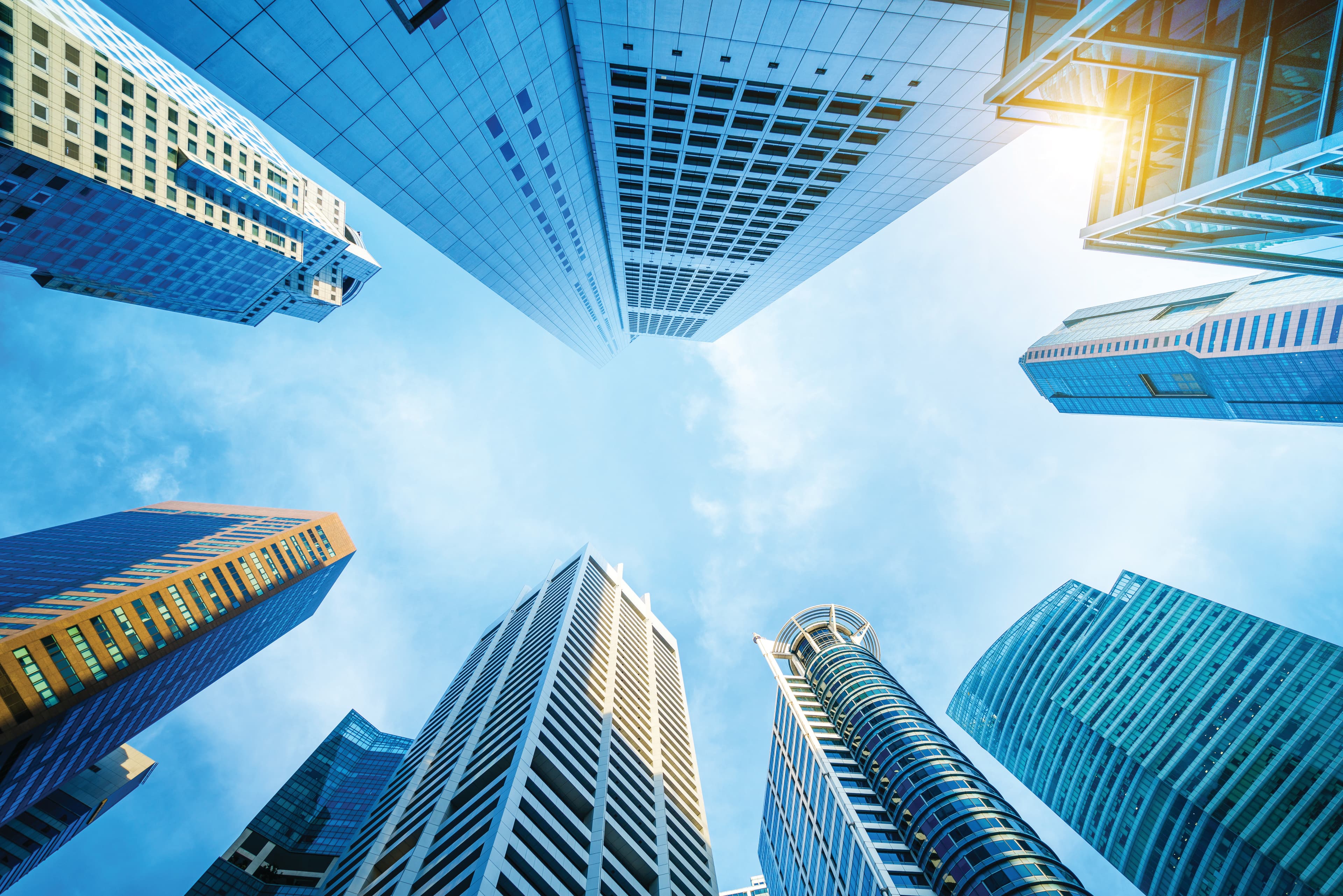 looking up into a sunny sky surrounded by LEED Buildings 