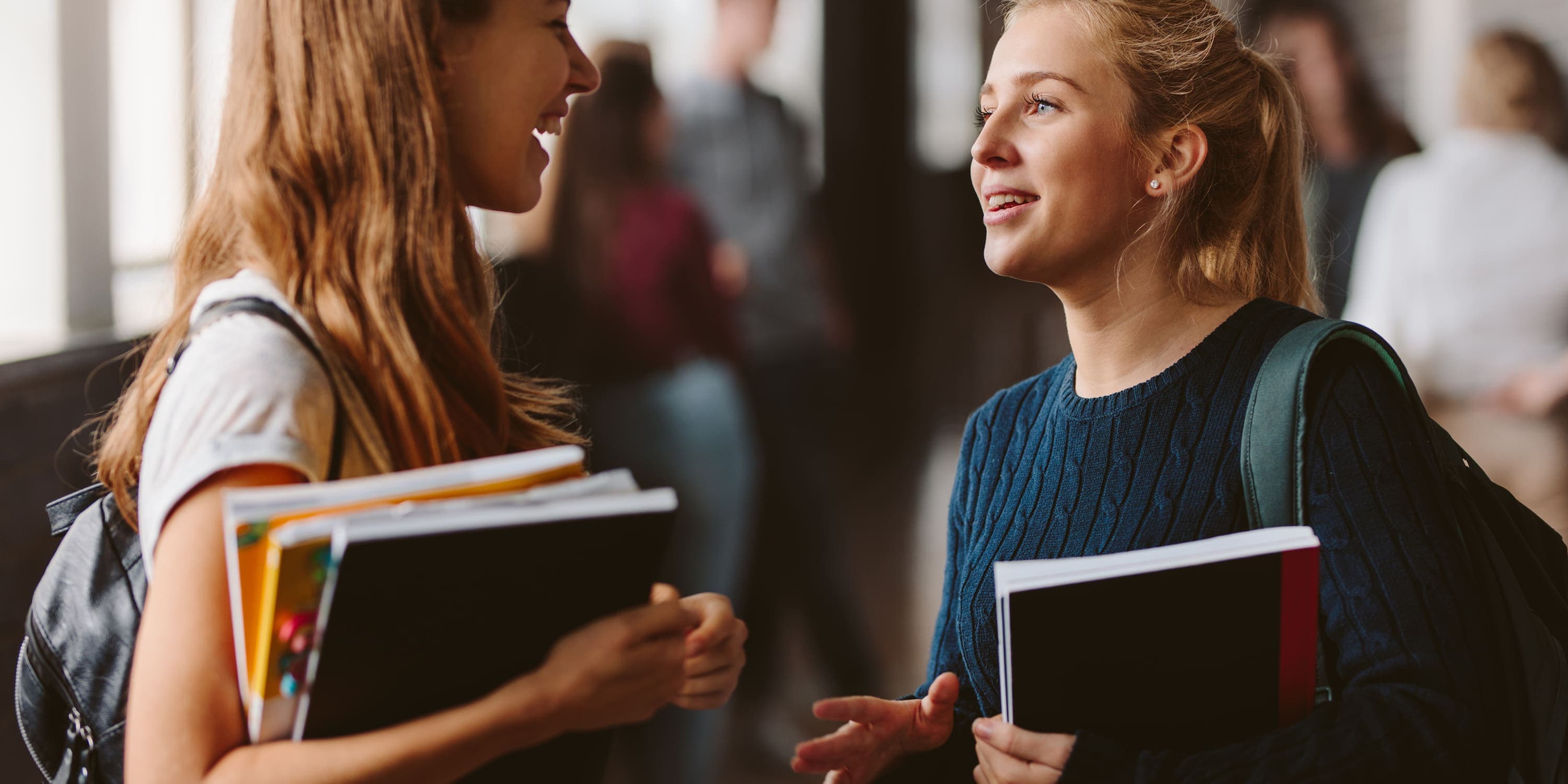 women at school with notebooks talking