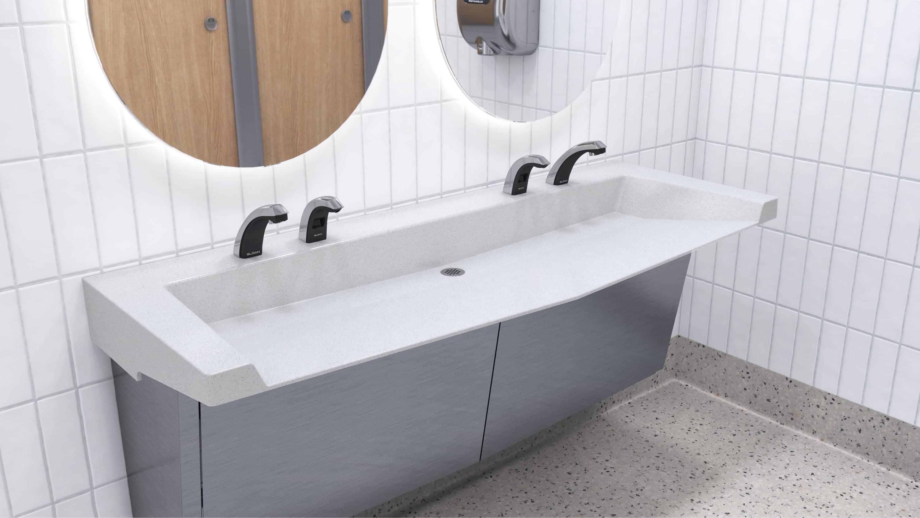 SloanStone® Quartz Arrowhead sink deck with angled front edge and open design, paired with matte black fixtures in a tiled commercial restroom.