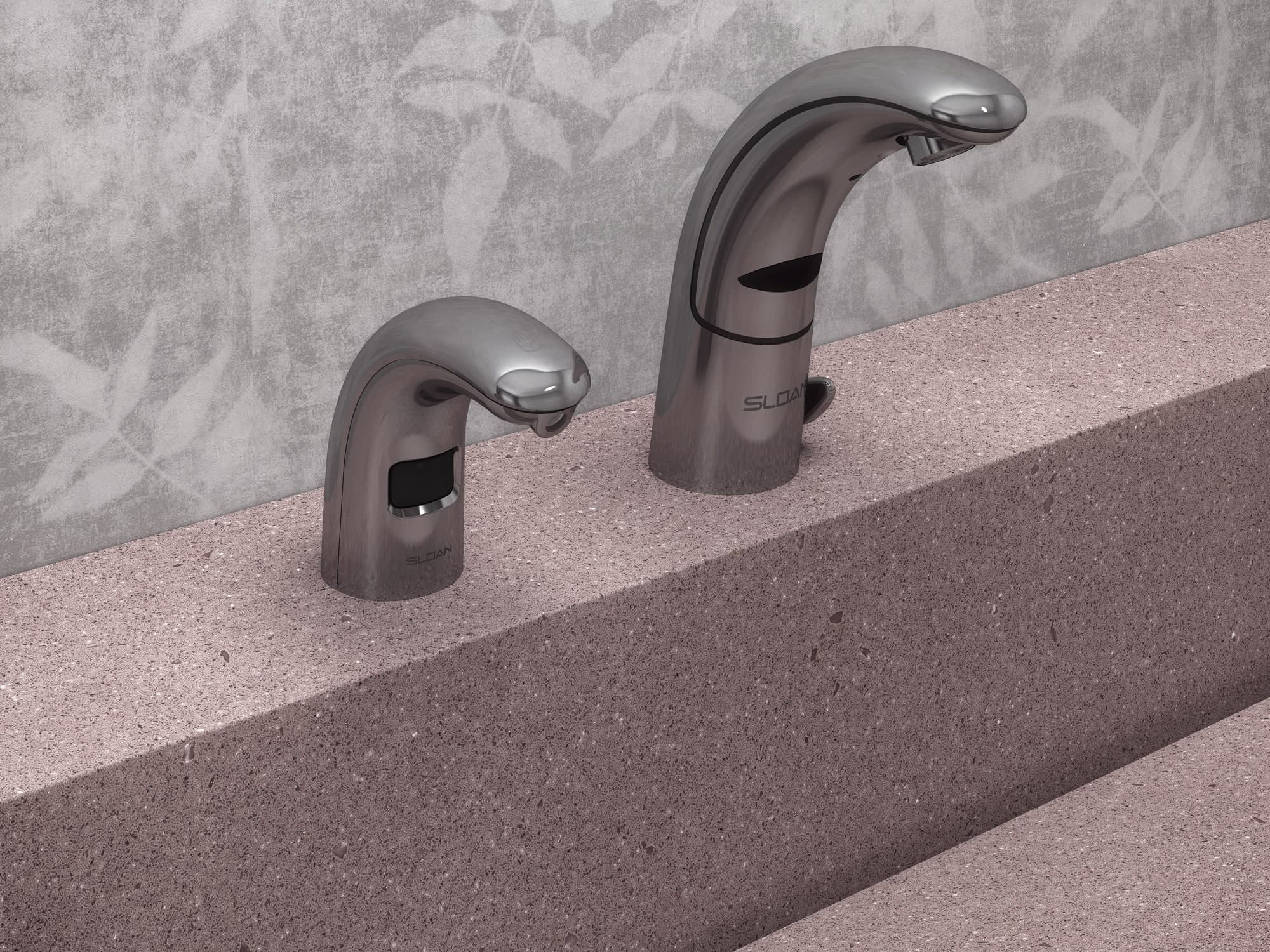 Side-by-side Sloan sensor-activated soap dispenser and faucet in a brushed metal finish, installed on a solid stone countertop with a textured gray wall in the background.
