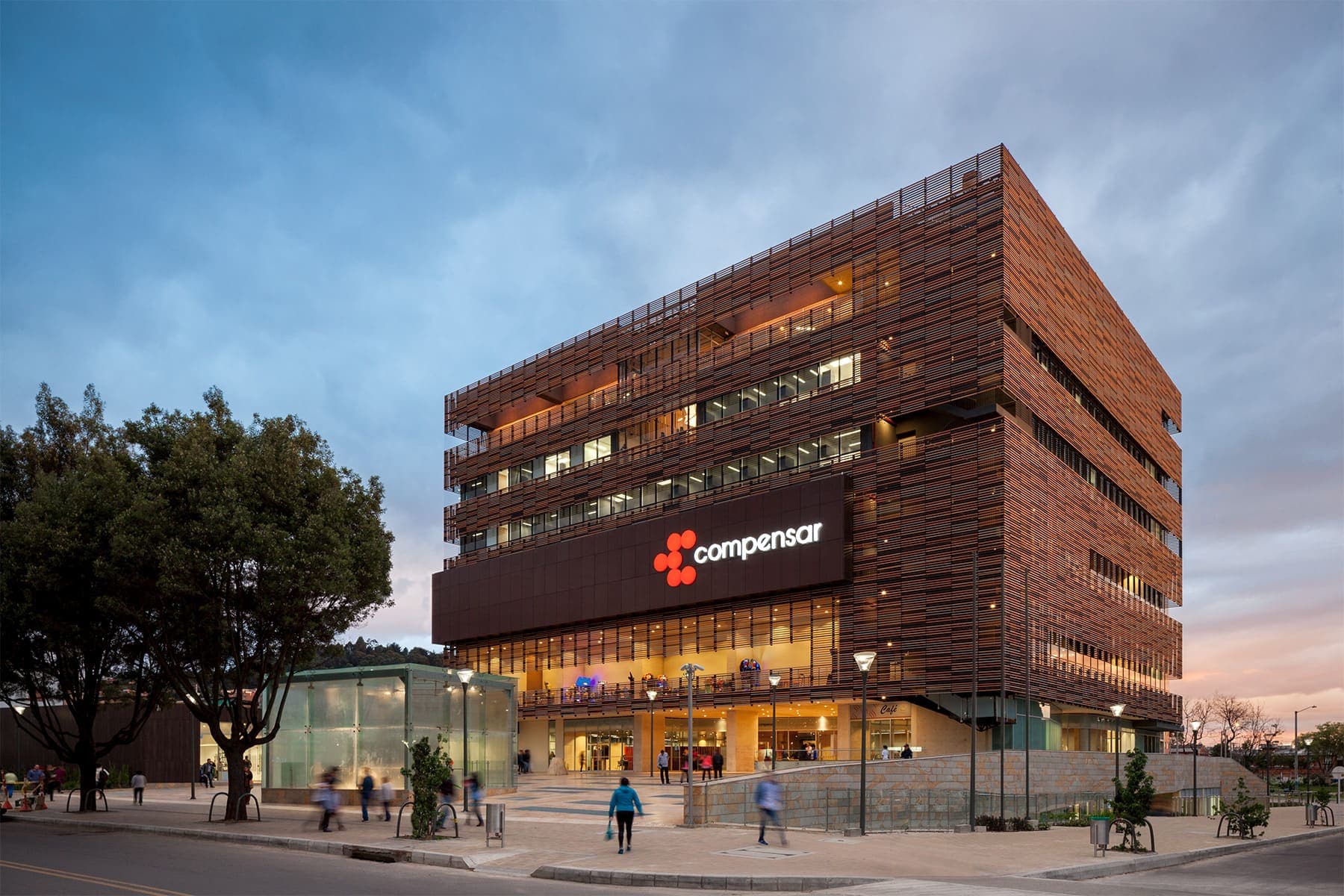 Street view of brick building at sunset with interior lights on
