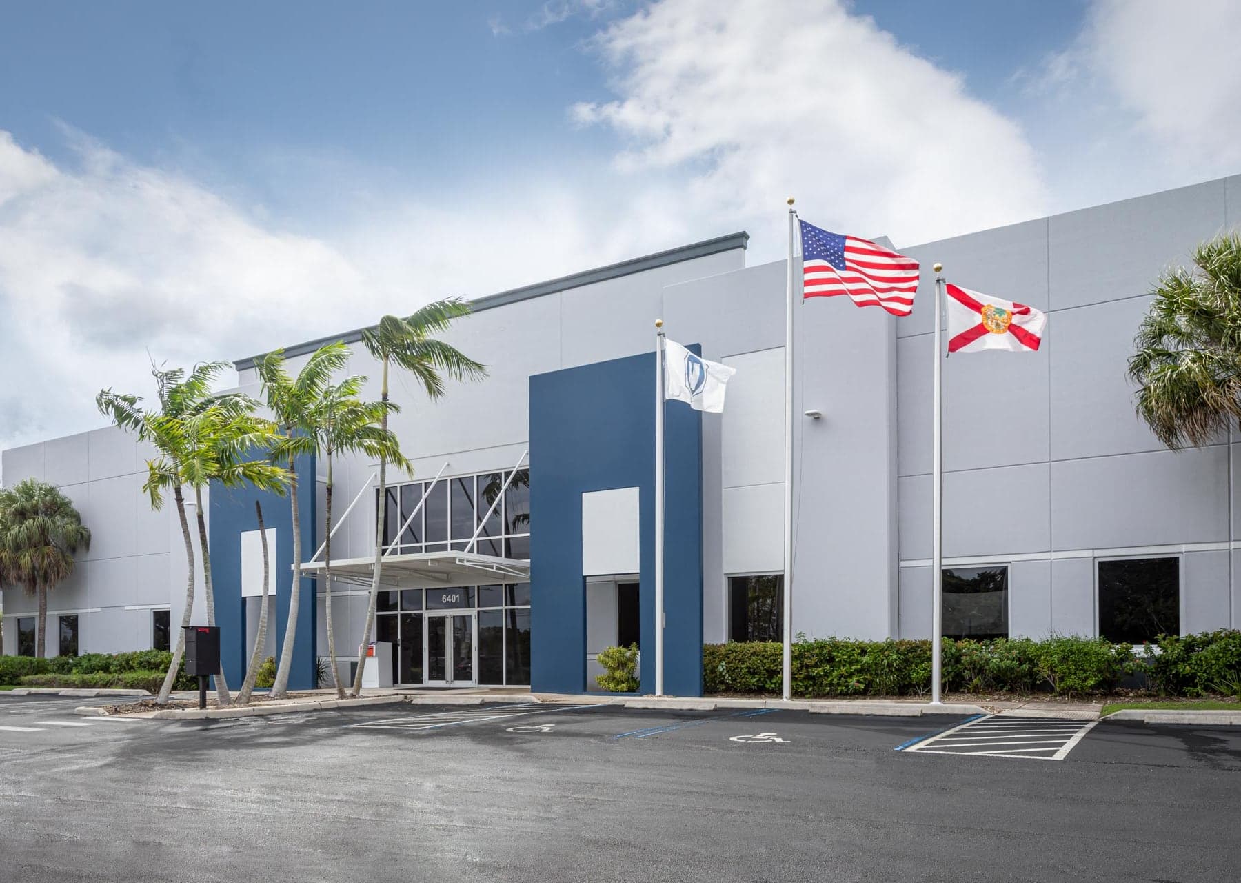 view of entrance of WR Nash building with blue and grey facade and 3 flags