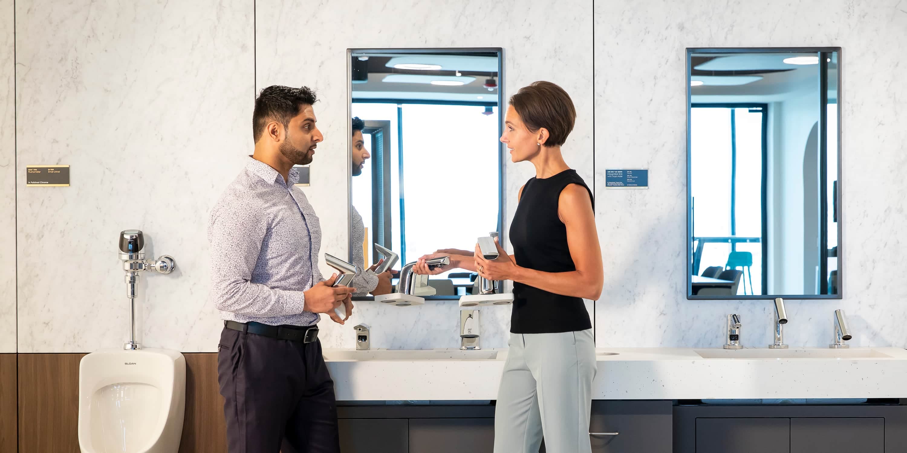 Two people discussing bathroom fixtures in a showroom.