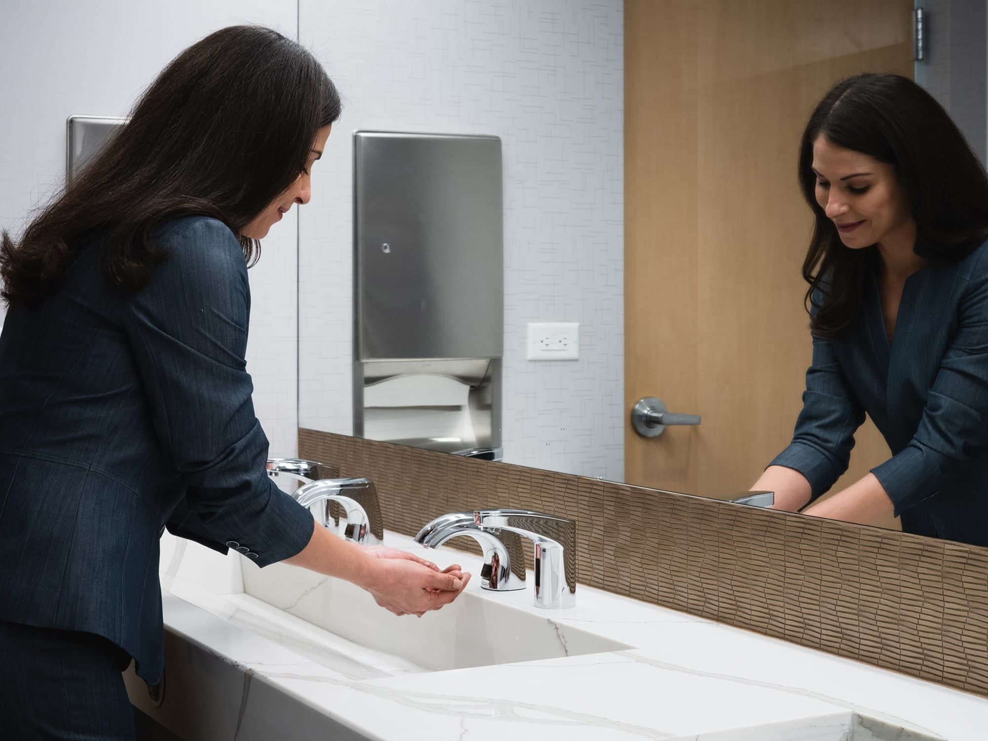 Female washing her hands with foam soap from a Sloan Top-fill Soap Dispenser