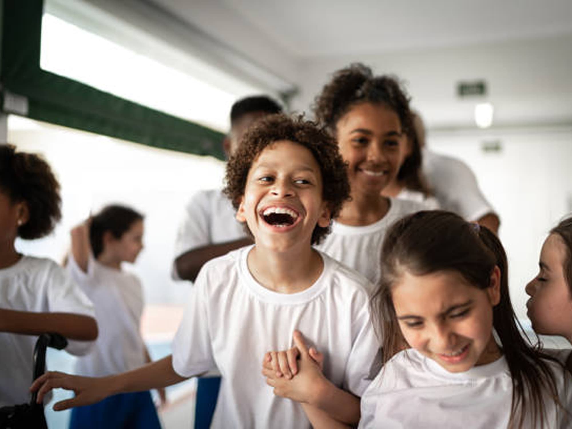 Smiling children holding hands and laughing together at a Maestro Cares Foundation program