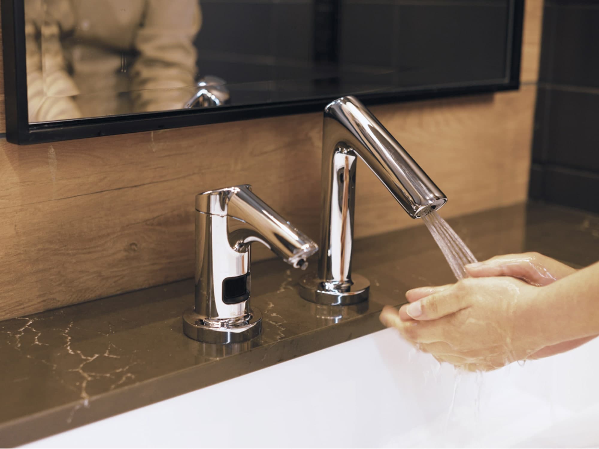 close up of person washing their hands using a Sloan sensor faucet and soap combo
