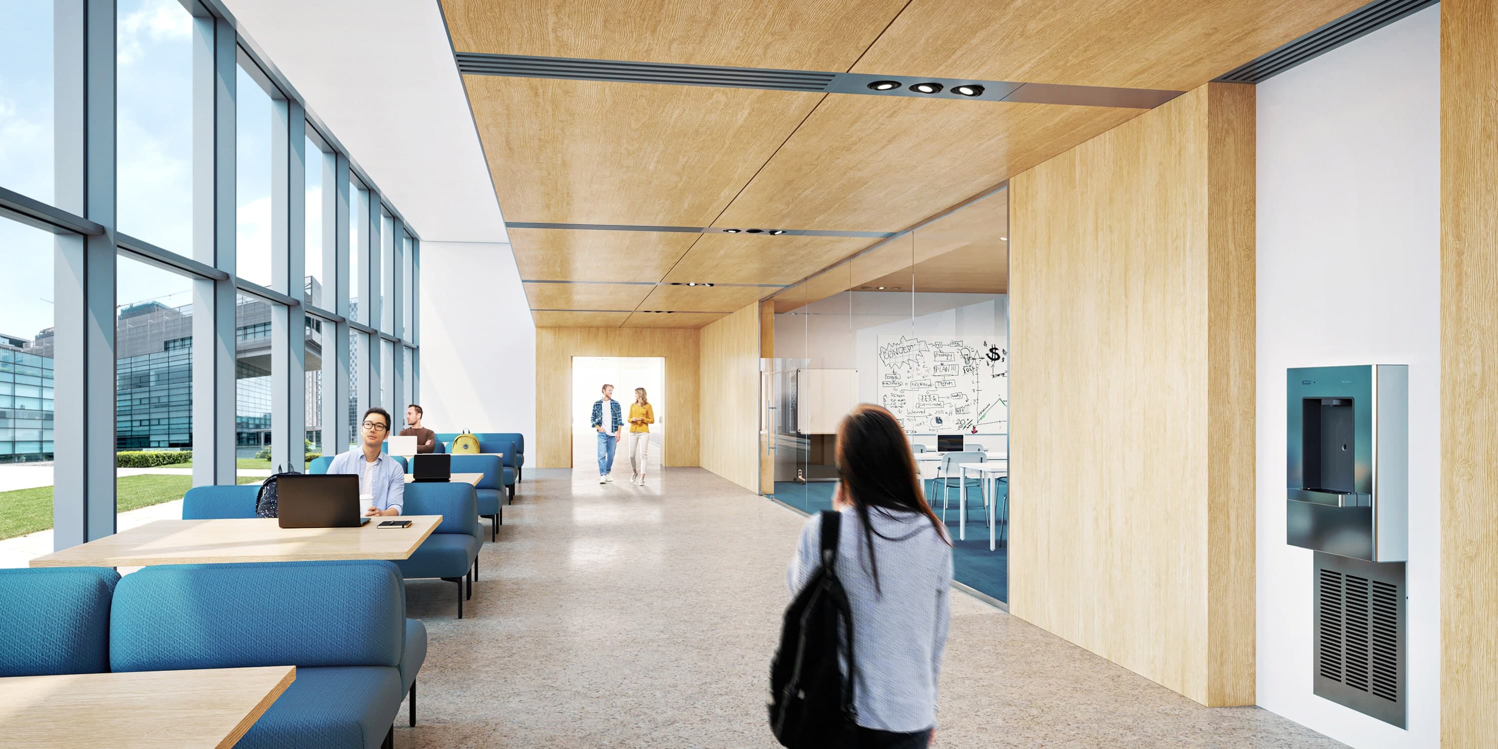 Modern collaborative learning space with blue lounge seating, wood ceiling, and large windows letting in natural light.
